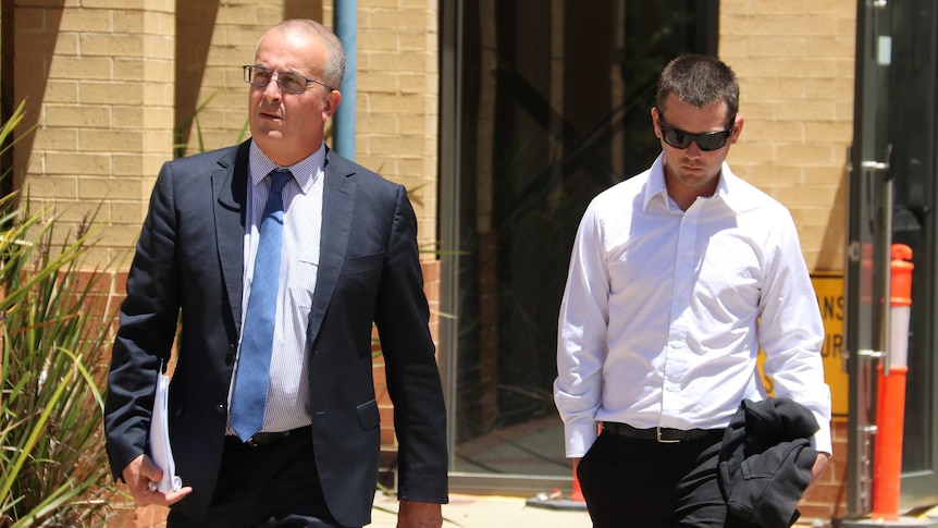 Lawyer John Hammond walks out of the court house with his client Ricky Swan, who is wearing a white shirt and black sunglasses.