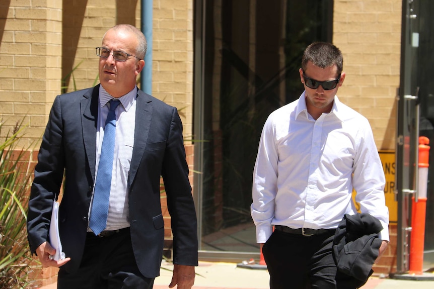 Lawyer John Hammond walks out of the court house with his client Ricky Swan, who is wearing a white shirt and black sunglasses.