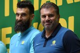 Mile Jedinak and Ange Postecoglou smile on stage at Martin Place during a public reception for the Socceroos.