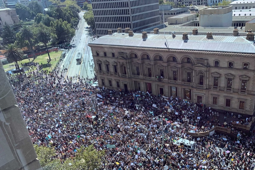 Thousands of people crowd into the street outside Victoria's Parliament House.