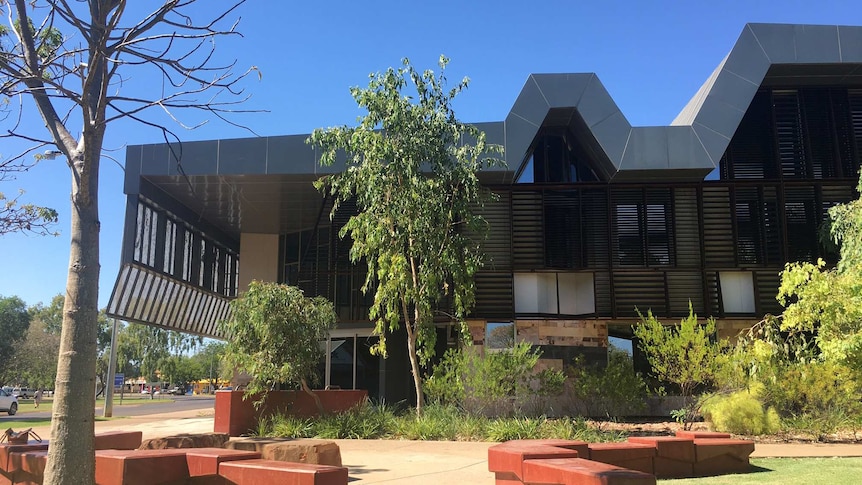 The Kununurra courthouse with trees and shrubs in the foreground.