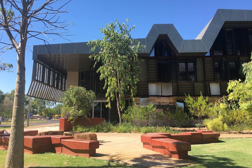 The Kununurra courthouse with trees and shrubs in the foreground.