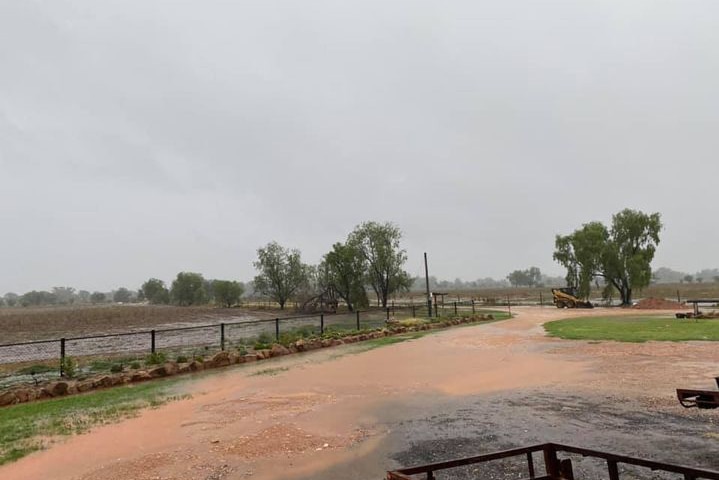 Rain sitting on a road and paddock.