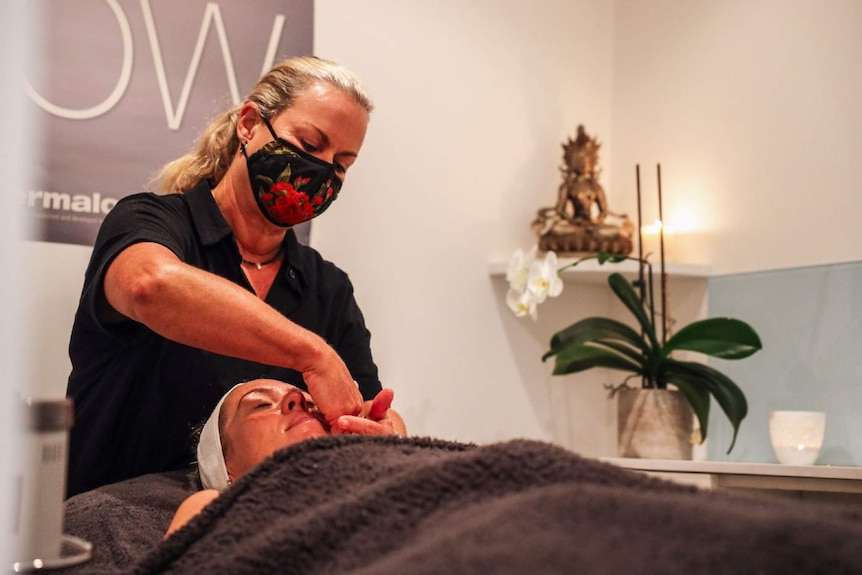 A woman performs a facial on another woman