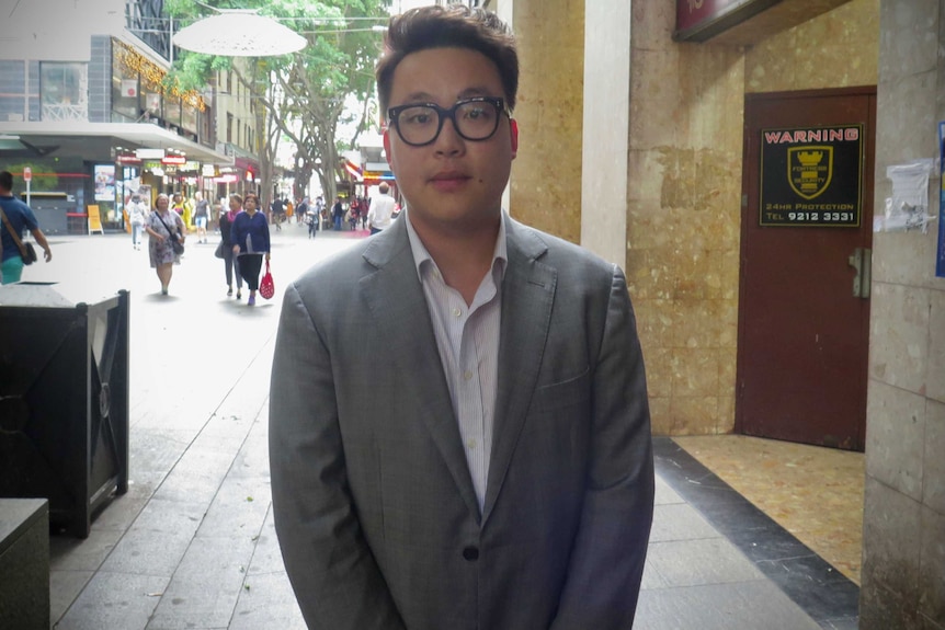 Mr Liu stands in the street in Sydney's Chinatown district.