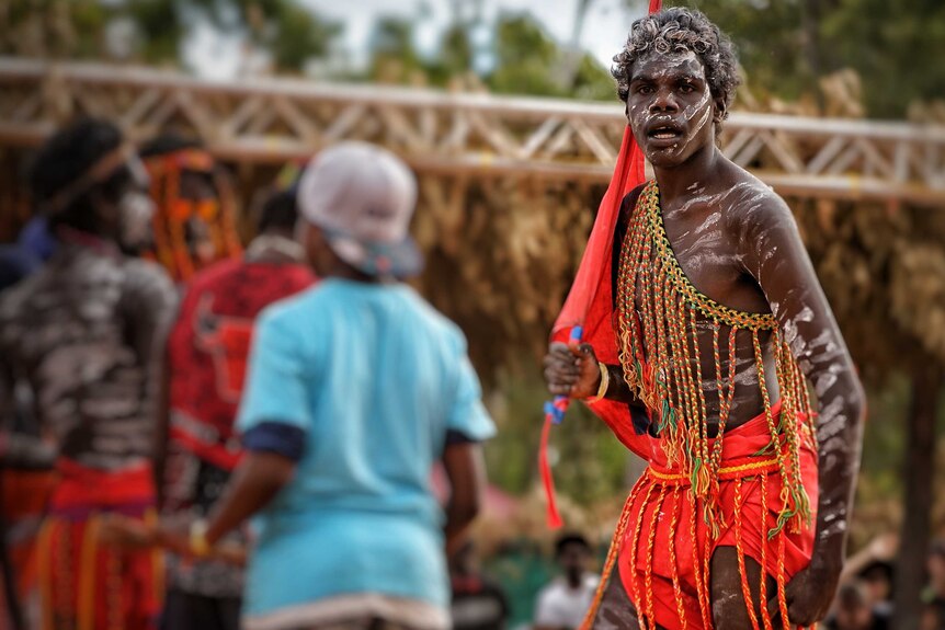 Young man in traditional dress dances at Garma