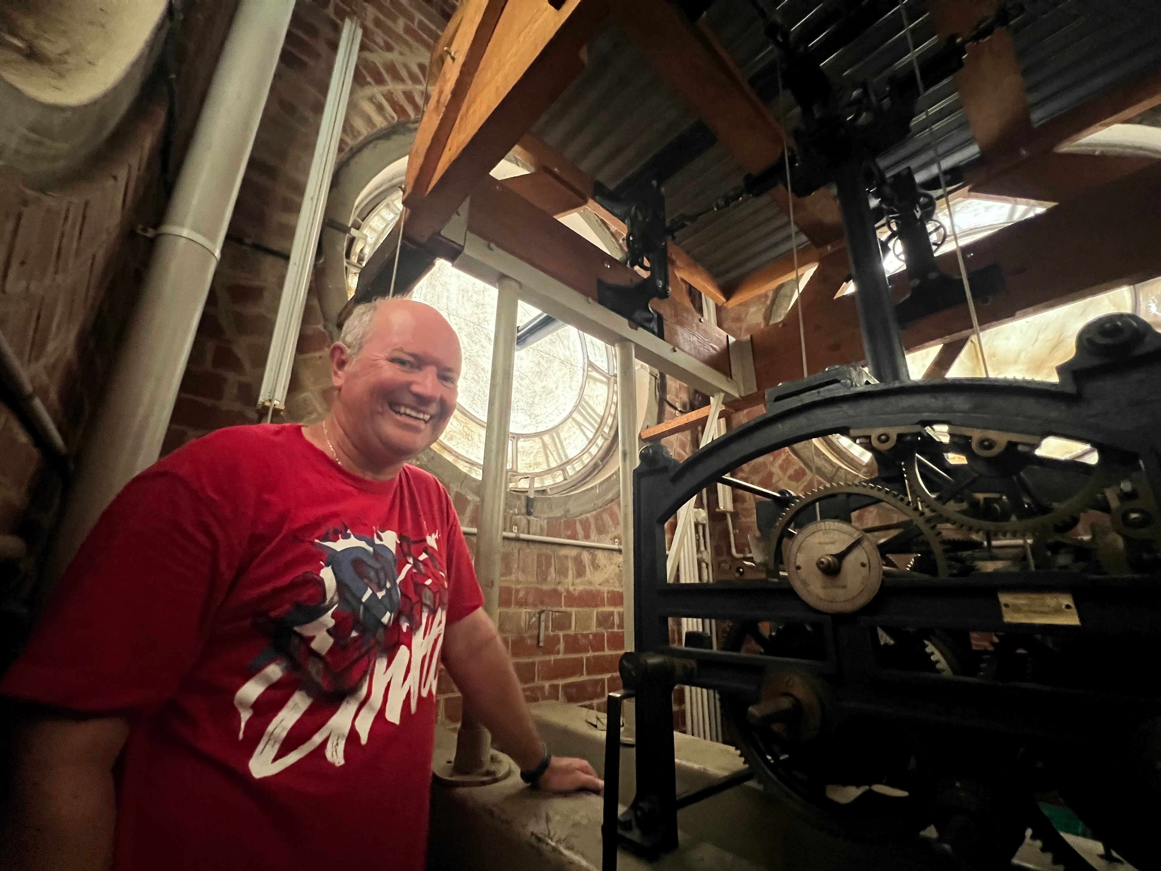 A man next to a clock mechanism.
