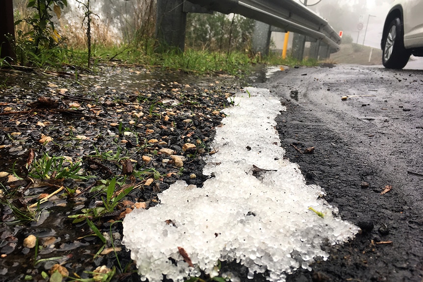 Hail melts on the side of a road.
