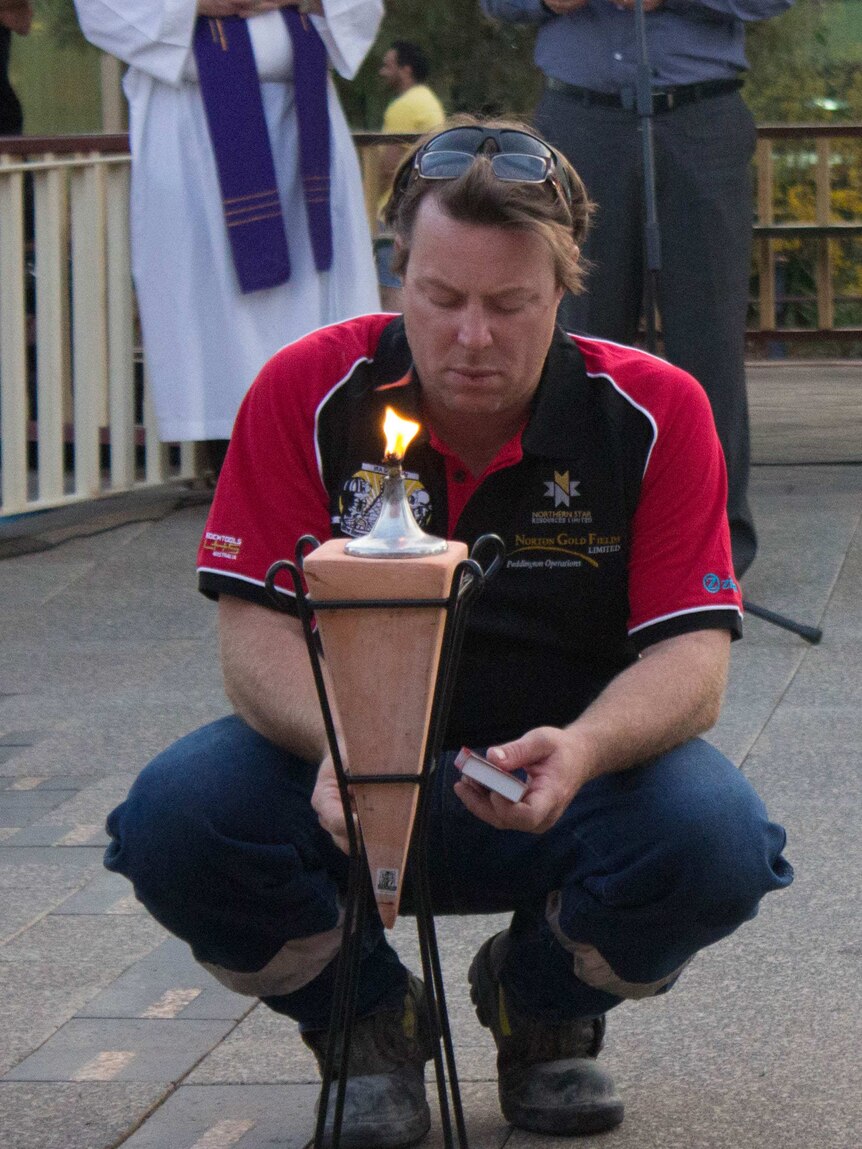 Mines Rescue committee chairman Kelly Bodman lights St Barbara's Lantern during the memorial service.