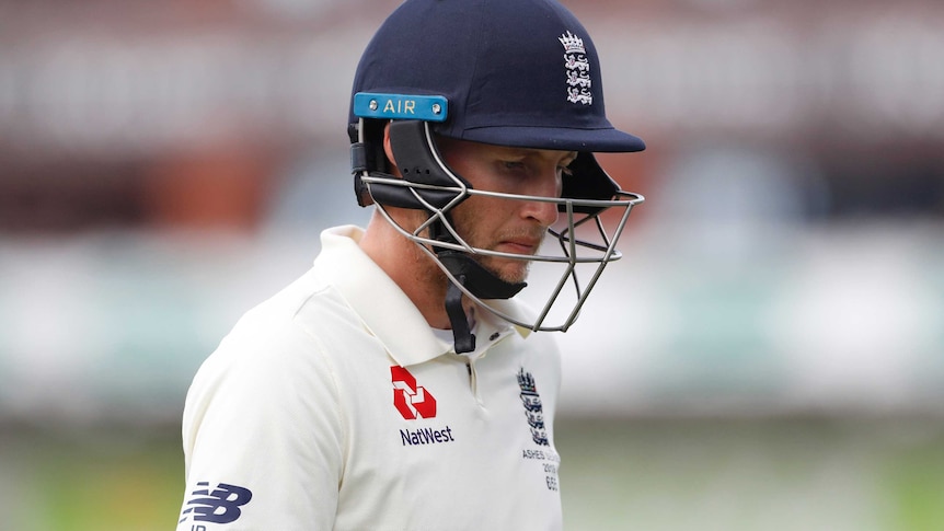 Joe Root walks off with his helmet on with a sombre expression on his face