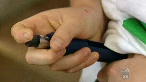 A young diabetic gives themselves an insulin injection