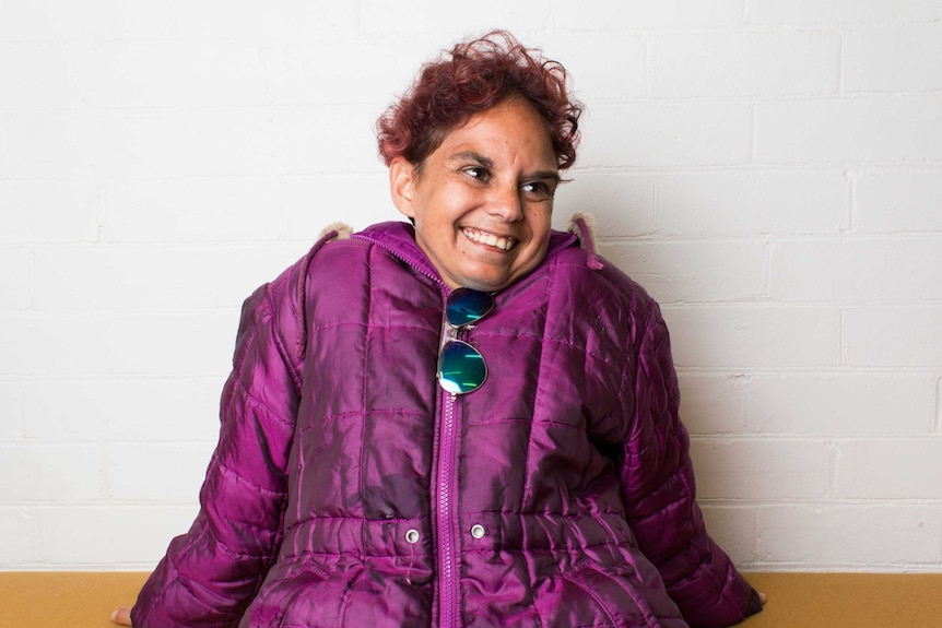 Cass Beasley sits in front of a white wall.