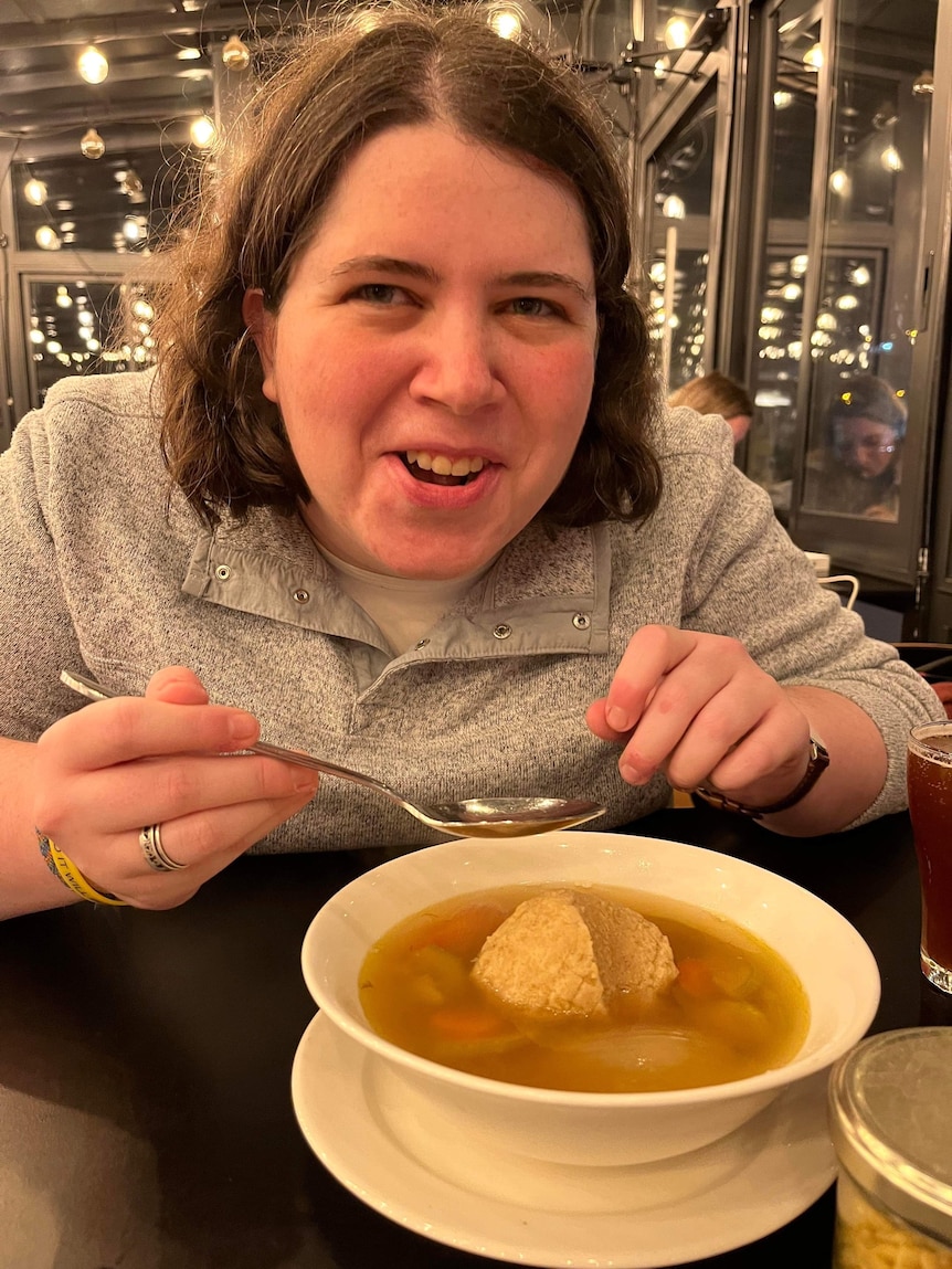 Shoshana eats a bowl of matzo ball soup