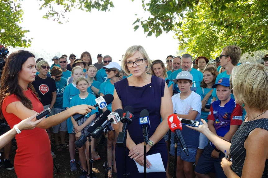 Zali Steggall speaks in front of journalists at a press conference in a park.