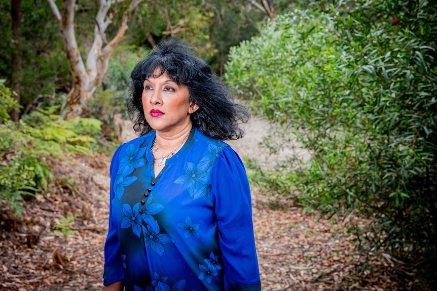 A woman in bushland looking away from the camera