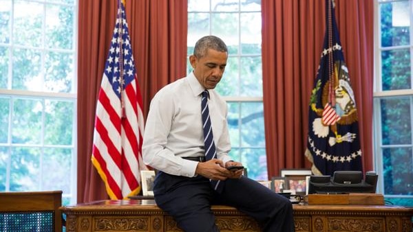 US president Barack Obama tweets on his phone