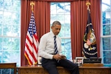 US president Barack Obama tweets on his phone