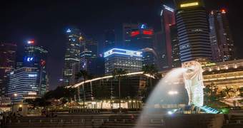 General view of Singapore at night with the national icon of the city in the foreground.