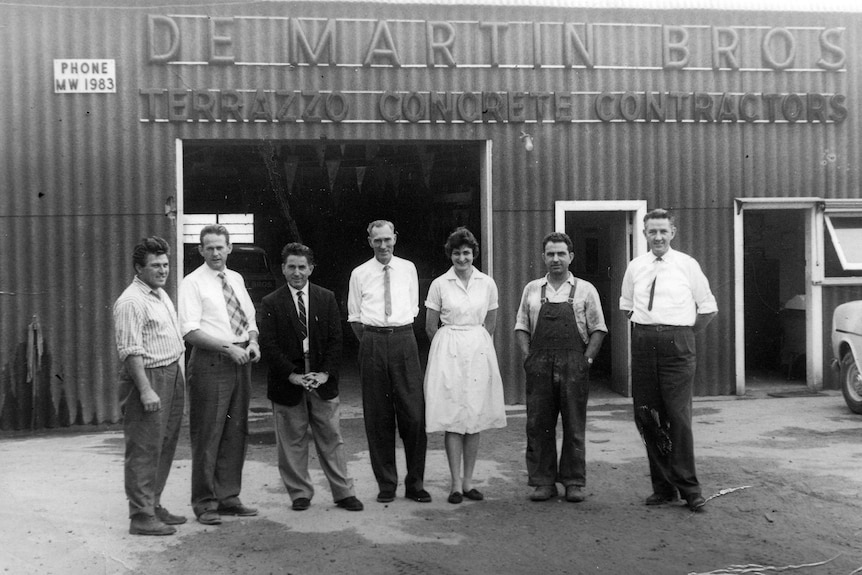 Black and white photo of employees outside an industrial shed
