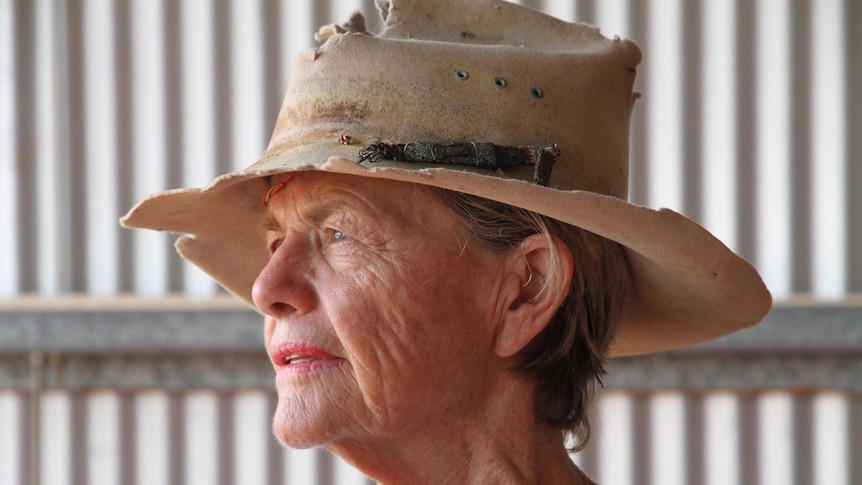 Penny Button wears a worn-out Akubra hat, looking out into the distance.
