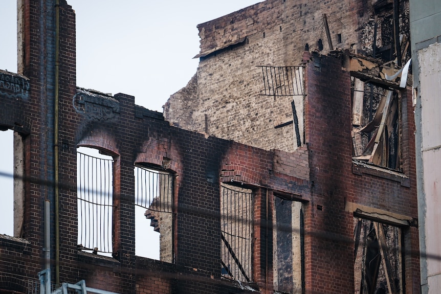 The side of a brick building that's been charred and blackened by fire