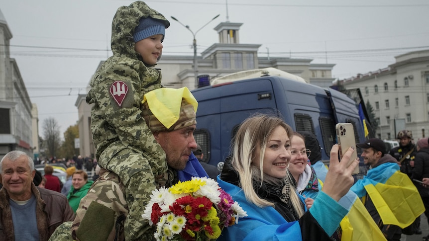 Kherson residents take photos with Ukrainian servicemen as part of celebrations.