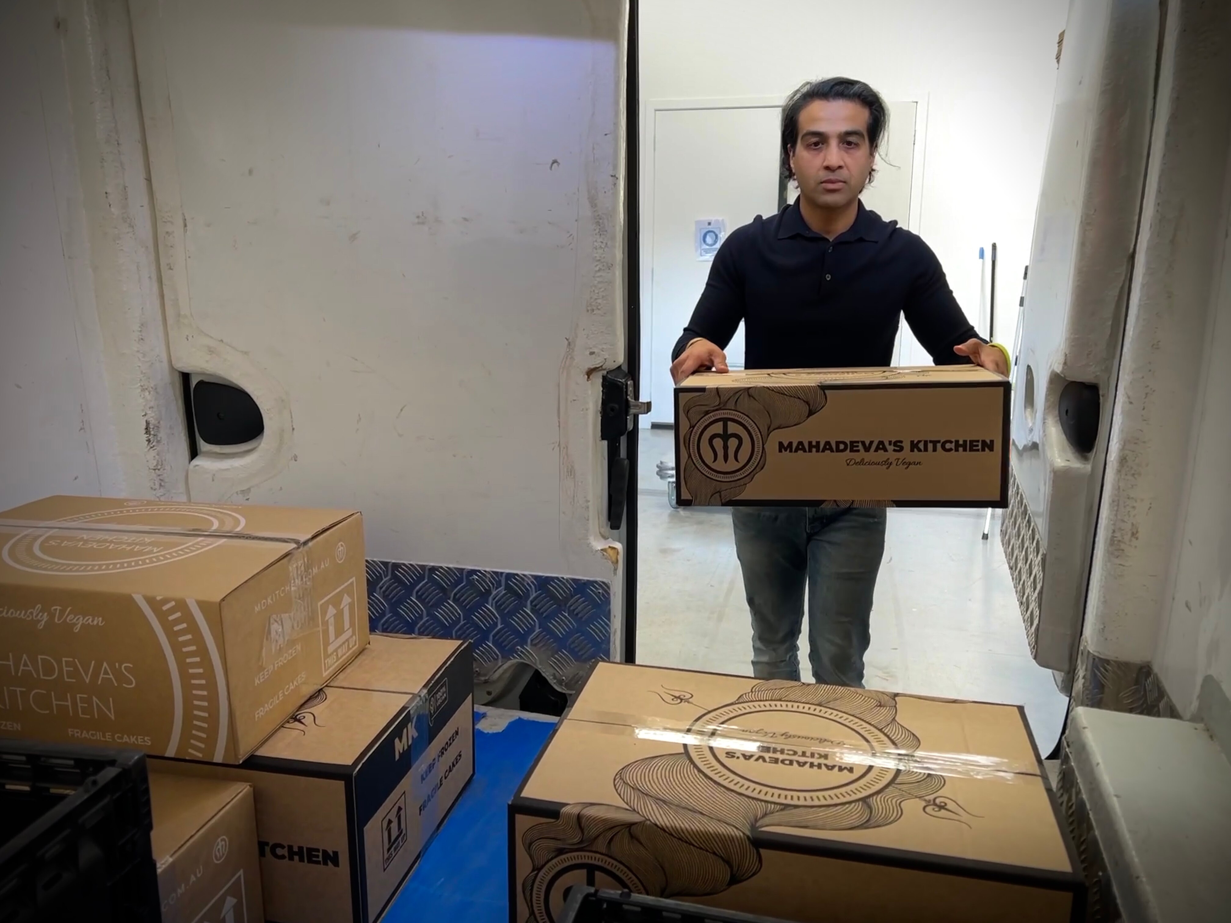 A man puts a box into a refrigerated van 