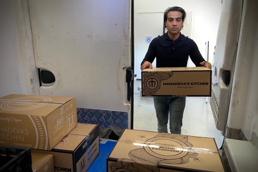 A man puts a box into a refrigerated van 