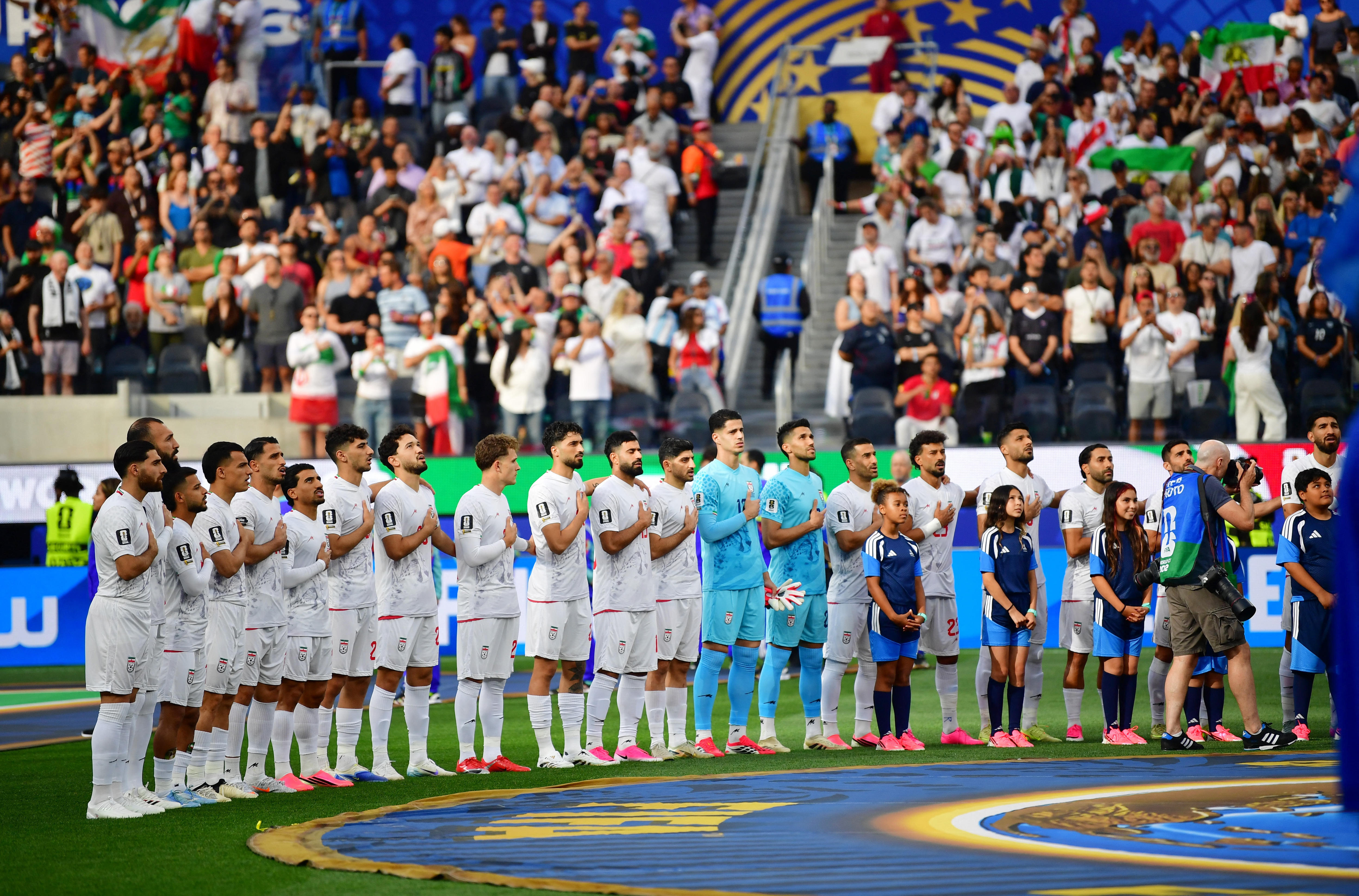 Iran men's players line up and sing the national anthem with hands on hearts
