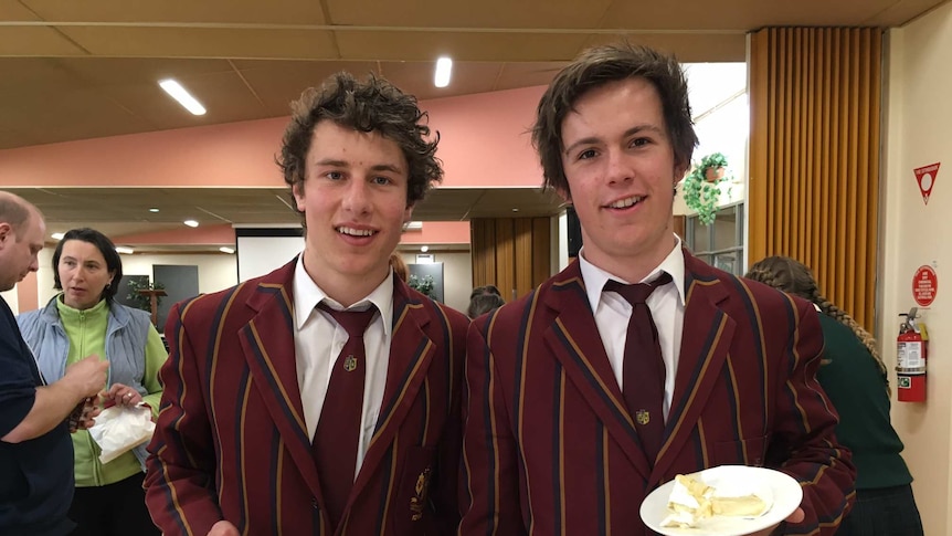 Two boys holding plates with cheese on them