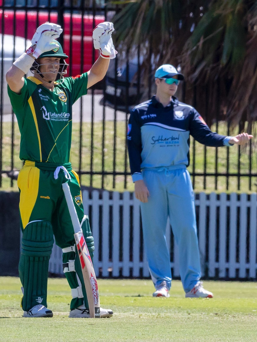 Steve Smith directs fieldsman, as David Warner gestures to the pavilion at Coogee Oval.