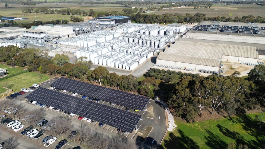 A birds eye view of the production centre with a solar panel car park and solar panels installed on the buildings roof