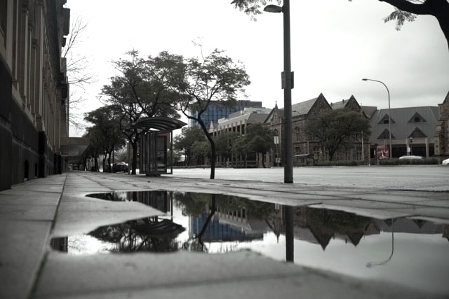 A puddle on the footpath of a deserted city