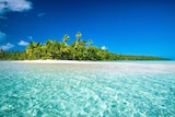 An island with white sandy beaches, turquoise water, swaying palms and blue sky.