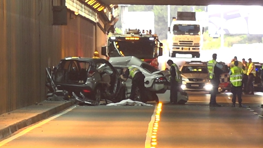 police observing a car wreck in a tunnel