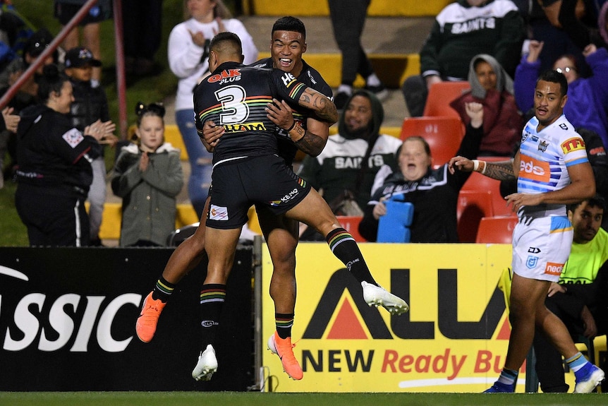 Brian Too and Dean Whare hug while leaping in the air. In the background, Panthers fans celebrate.