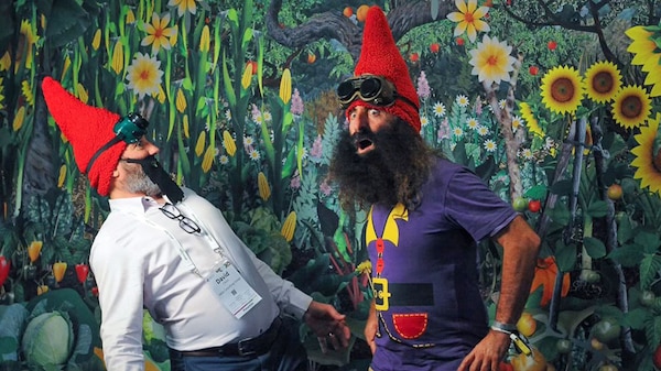 Costa the Gnome with man wearing false beard standing in front of a garden mural.
