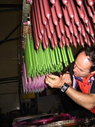 Man inspects candles hanging from roof