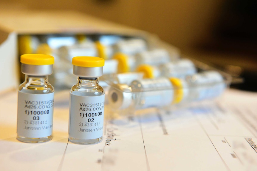 Vials of vaccines sit on top of a medical form