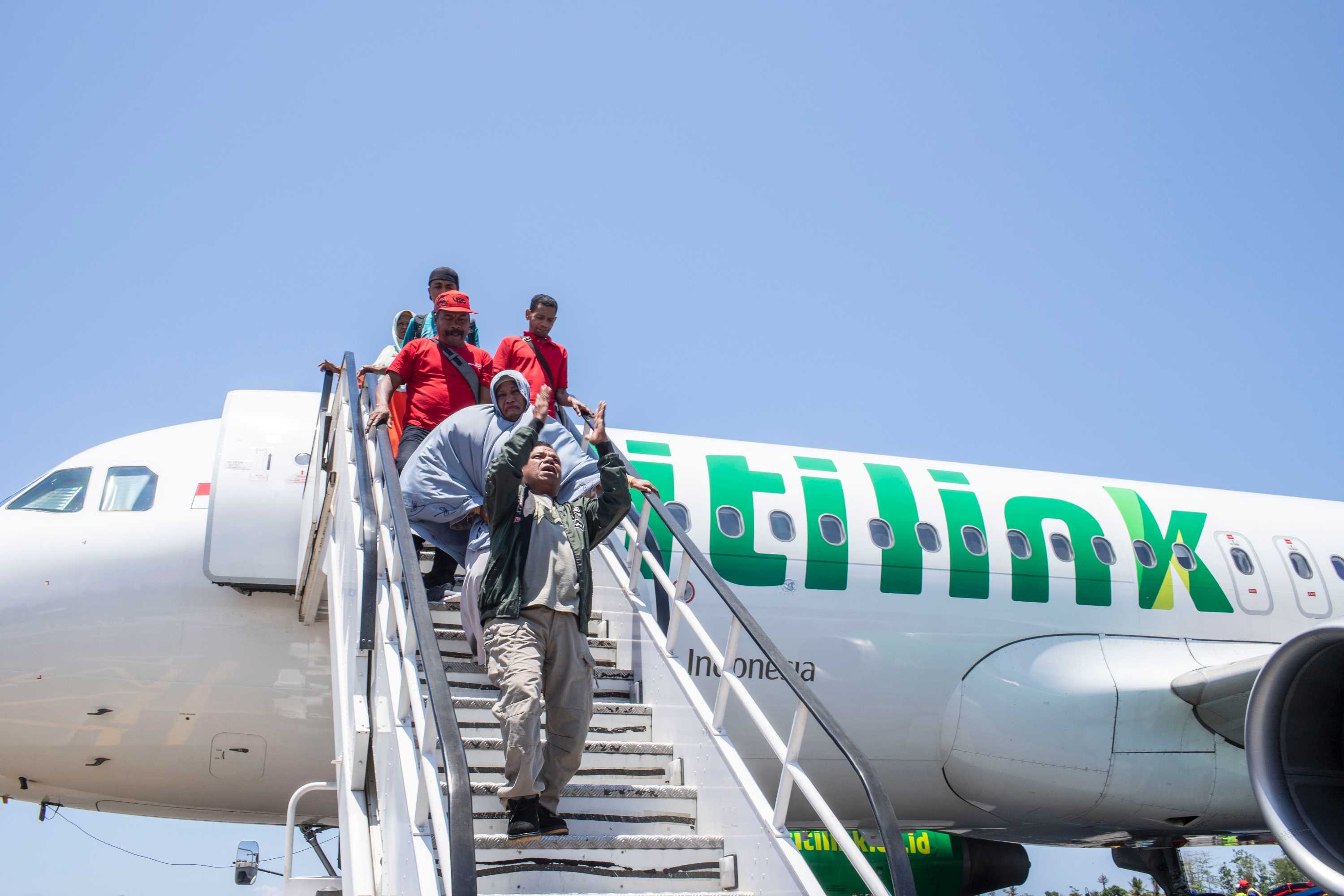 A man walks down stairs from a plane.