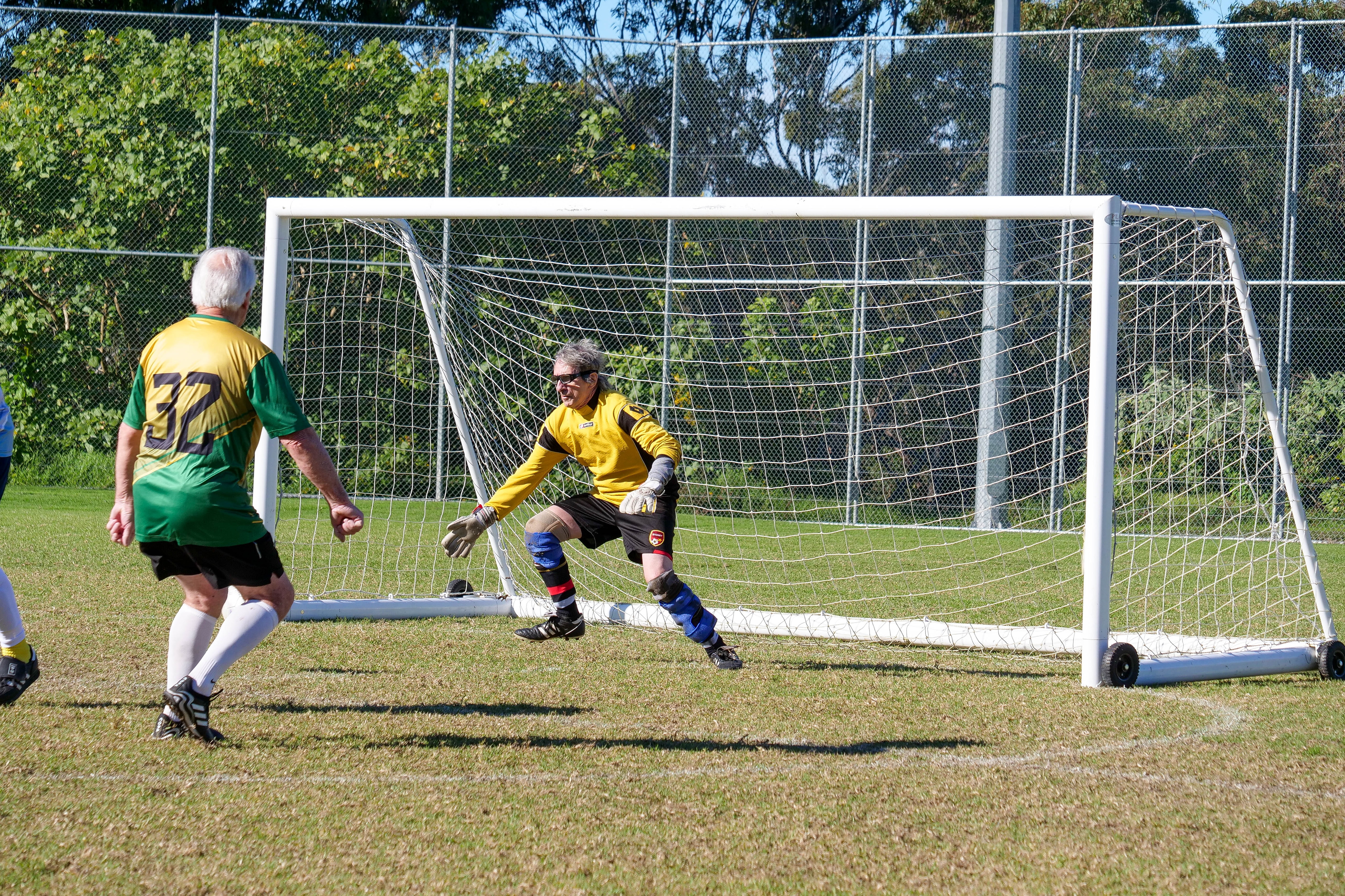 a goalkeeper dives to his right to save a goal in soccer