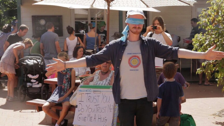 Peter Sharp, a 'social media artist', stands blindfolded waiting for hugs from strangers.