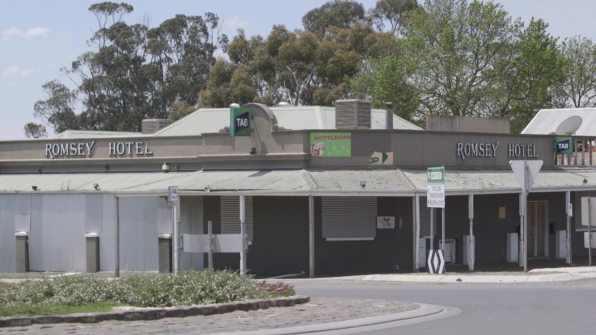 a photo of the outside of a grey pub on the corner of a street