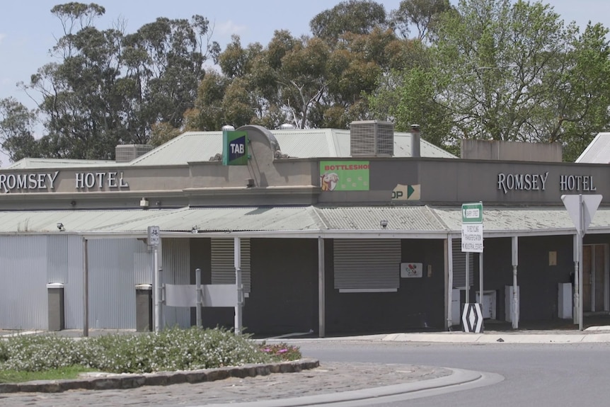 a photo of the outside of a grey pub on the corner of a street