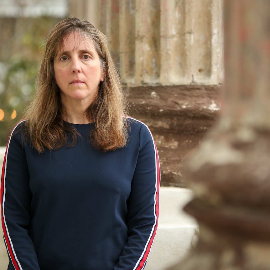 A woman standing on a court house steps looking serious