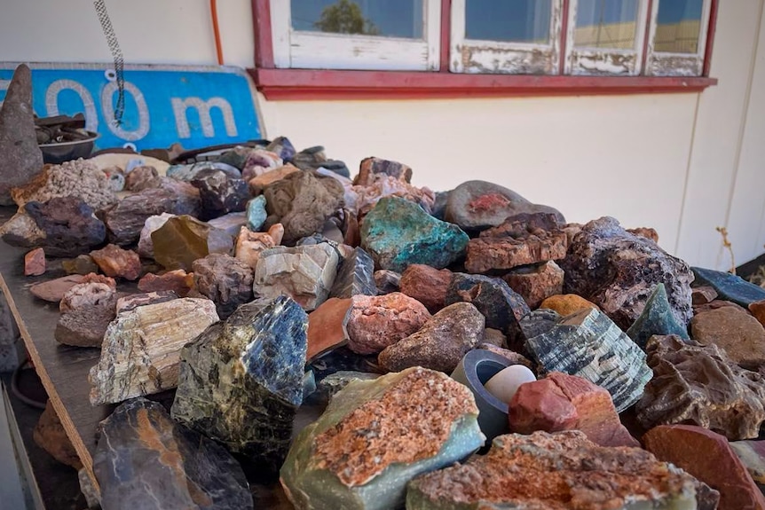 a table brimming with colourful rocks of different geological varieties 