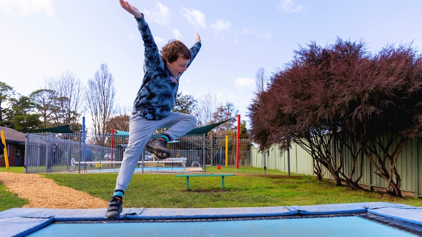A boy jumping on a trampoline.