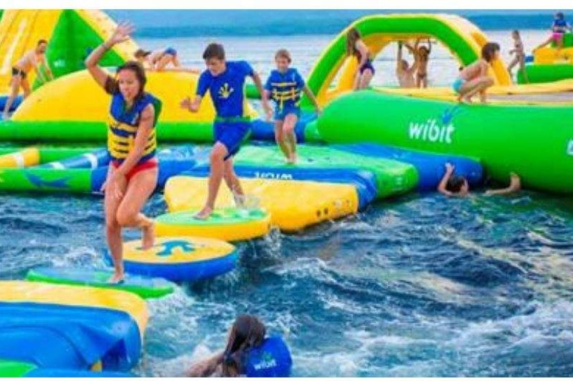 Kids playing on an inflatable water park.