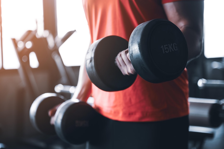 Image of a man's torso and arms lifting weights