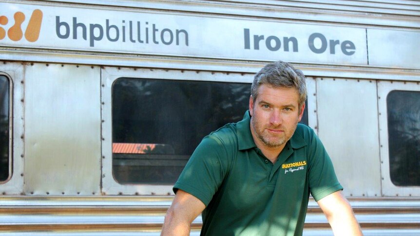 Brendon Grylls in front of a BHP Billiton iron ore train
